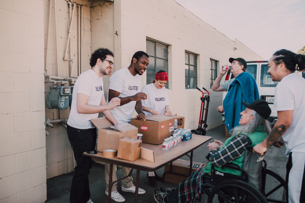 A group of diverse volunteers engaging in a community service activity outdoors, providing aid and support.